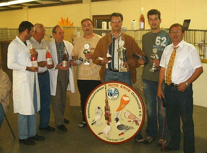 Gruppenfoto der Champion-Züchter mit Pokalen, Preisrichtern und dem 1. Vorsitzenden