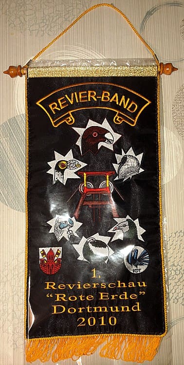 Schwarzes Revierband mit Förderturm, Tauben und der Aufschrift „1. Revierschau Rote Erde Dortmund 2010“